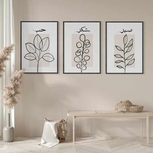 Three framed abstract leaf artworks on a beige wall with a bench and decorative items below.