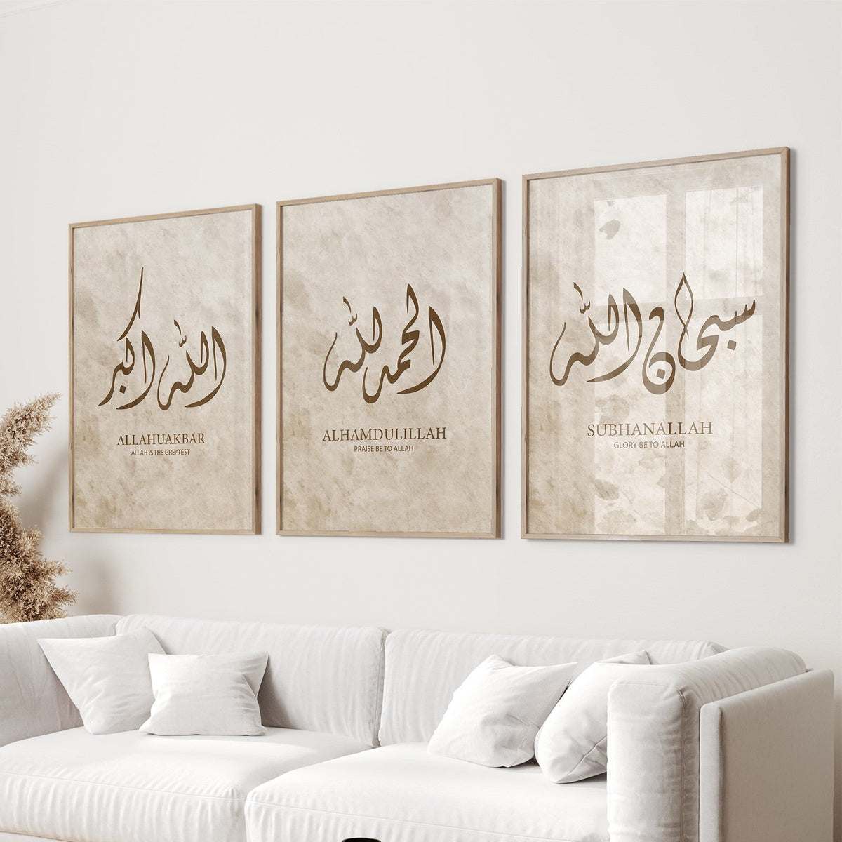Three framed Arabic calligraphy pieces on a wall above a white sofa.