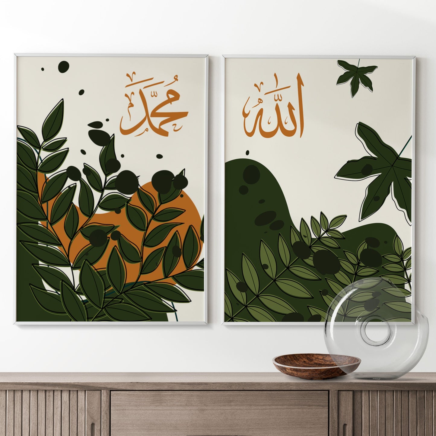 Two framed artworks with Arabic calligraphy and leaf designs on a white wall above a wooden cabinet.