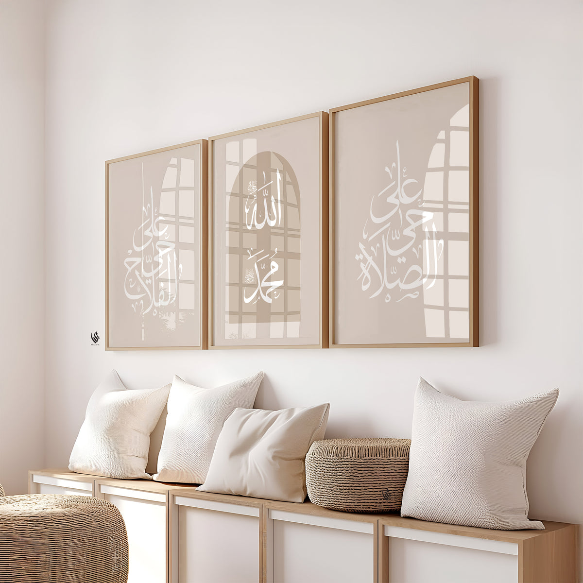 A set of three beige framed Islamic wall art pieces placed above a shelf with pillows, featuring Arabic calligraphy that reads "Hayya alasalah" and "Haya alal falah," which translates to "Come to prayer" and "Come to success," respectively, along with the names of Allah and Prophet Muhammad saw.