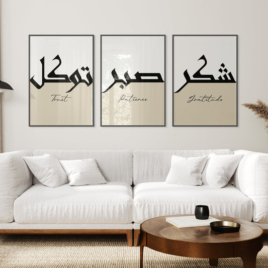 White sofa in a living room with three framed Arabic calligraphy artworks on the wall.