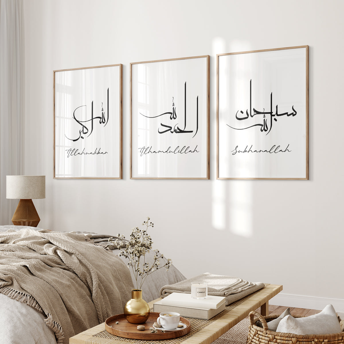 Set of three white Dhikr Islamic wall art prints with black Arabic calligraphy displayed above a neutral bed.
