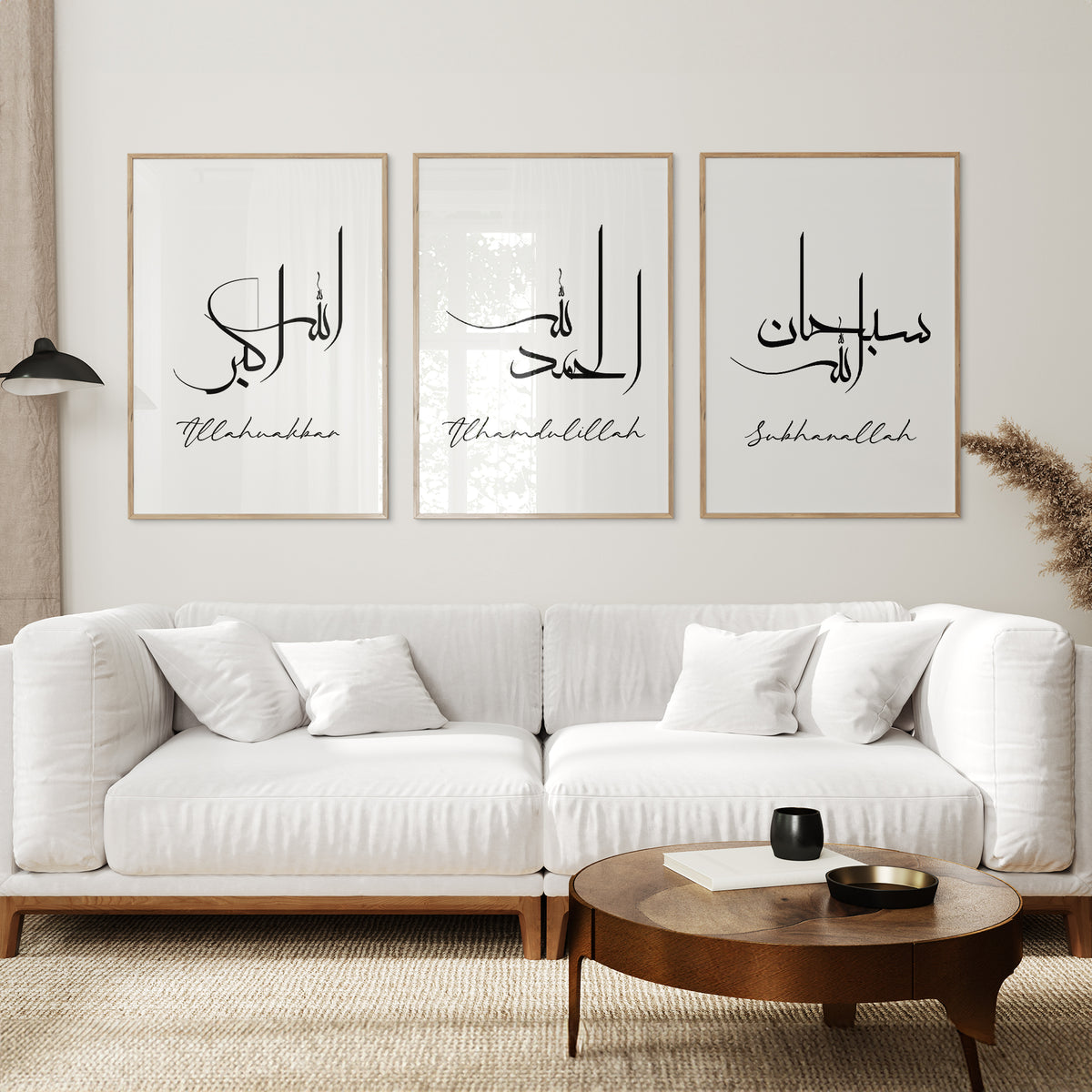 Three white Subhanallah, Alhamdulillah and Allahu Akbar prints in wooden frames above a white sofa.