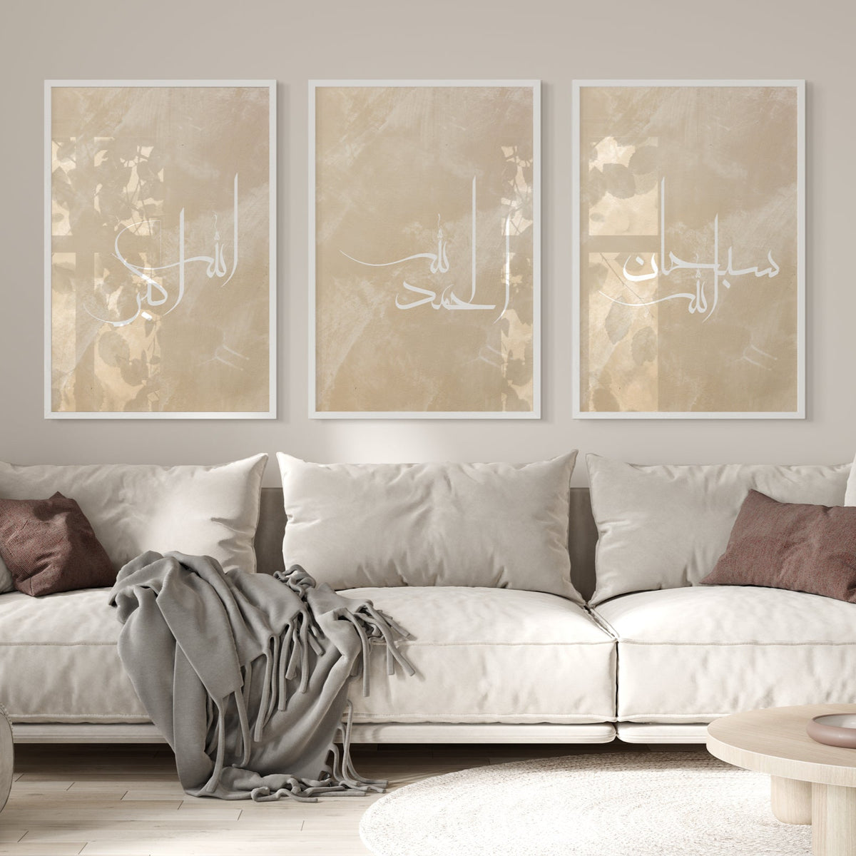 Three abstract art pieces on a wall above a white sofa with brown and gray cushions.
