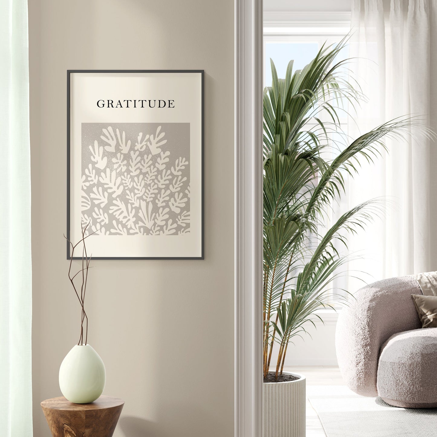 Living room with a 'Gratitude' poster on the wall, a plant, and a sofa.