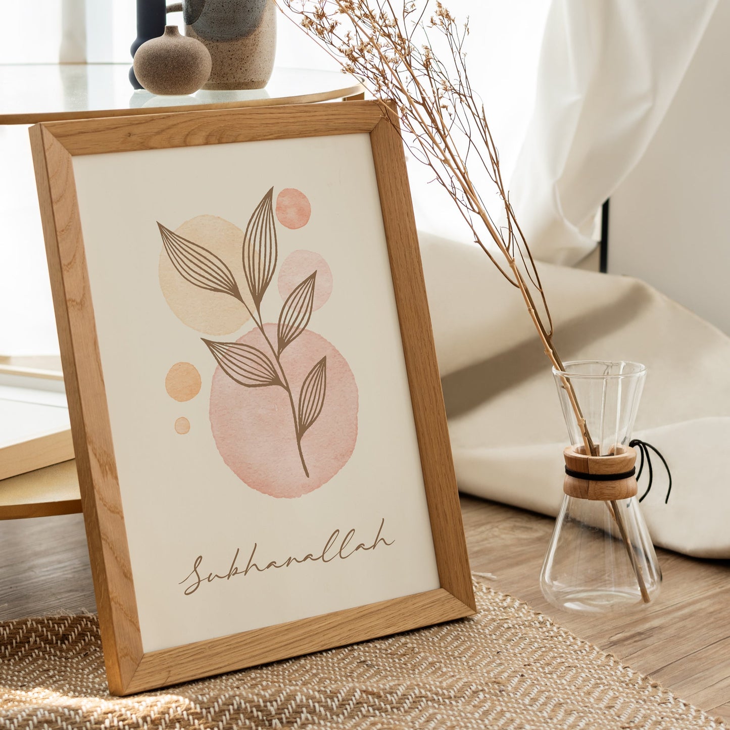 Framed artwork with leaf design and 'Sukkhanallah' text on a table with decor items.