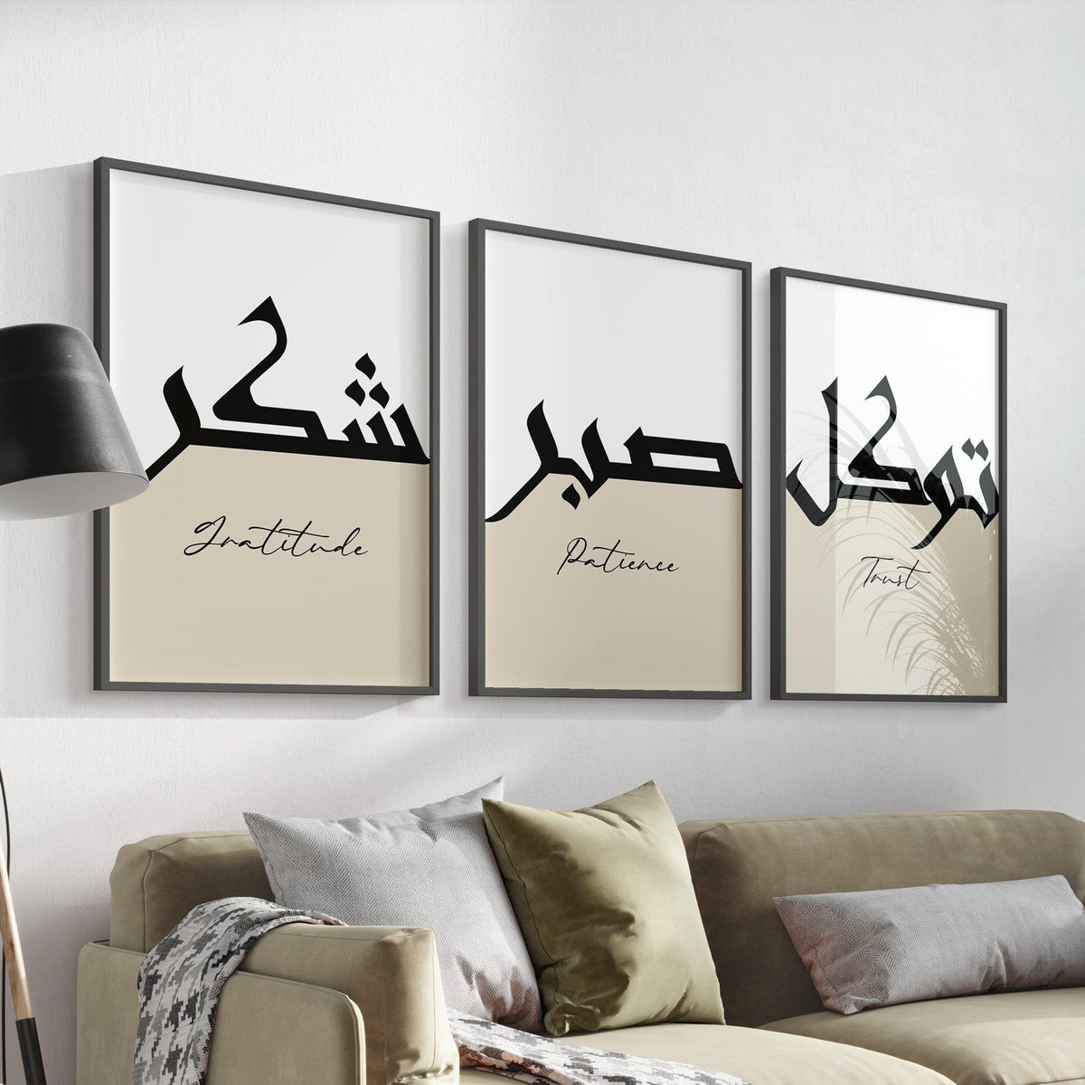 A set of three framed Islamic art prints with Arabic calligraphy hanging on a wall over a sofa, depicting the words 'Patience', 'Gratitude', and 'Trust' in Arabic script.