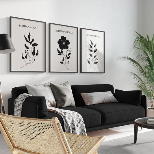 Modern living room with black sofa, decorative pillows, and framed botanical art on a white wall.