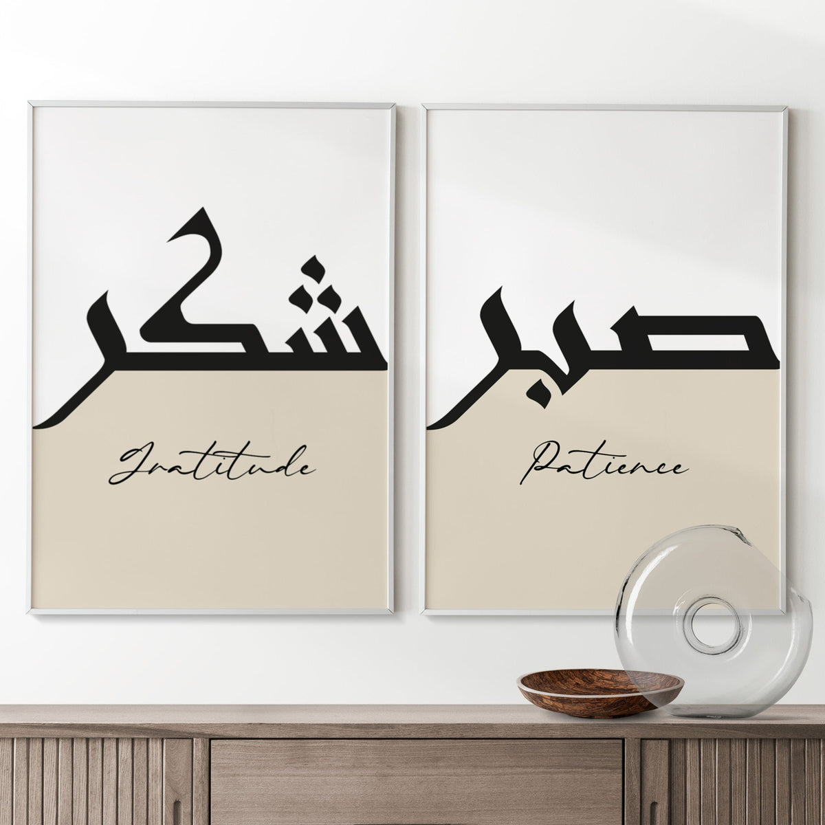Two framed prints with Arabic calligraphy and English words on a wall above a wooden cabinet.