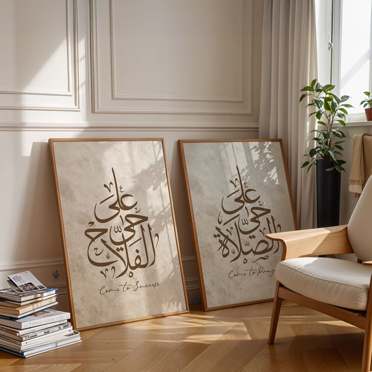 Two framed pieces of art with Arabic calligraphy Hayya Alas Salah come to prayer and success Islamic wall art print beige modern decor on a wall in a room with a chair and books.