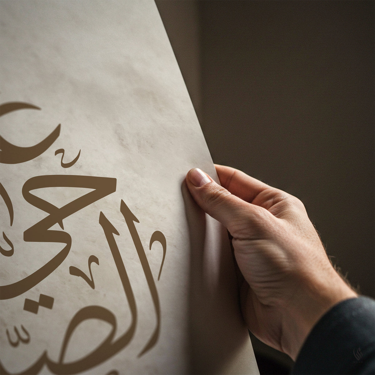 Hand holding a piece of paper with Arabic calligraphy