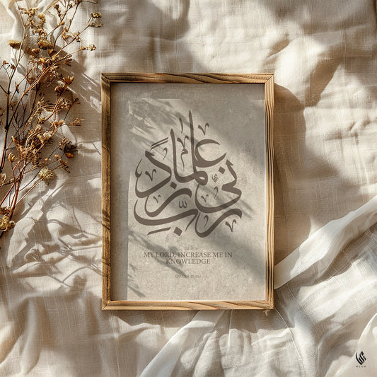 Rabbi Zidni Ilma Quran 20:114 wall art in a natural wood frame on cream linen, styled with dried flowers and soft sunlit shadows.