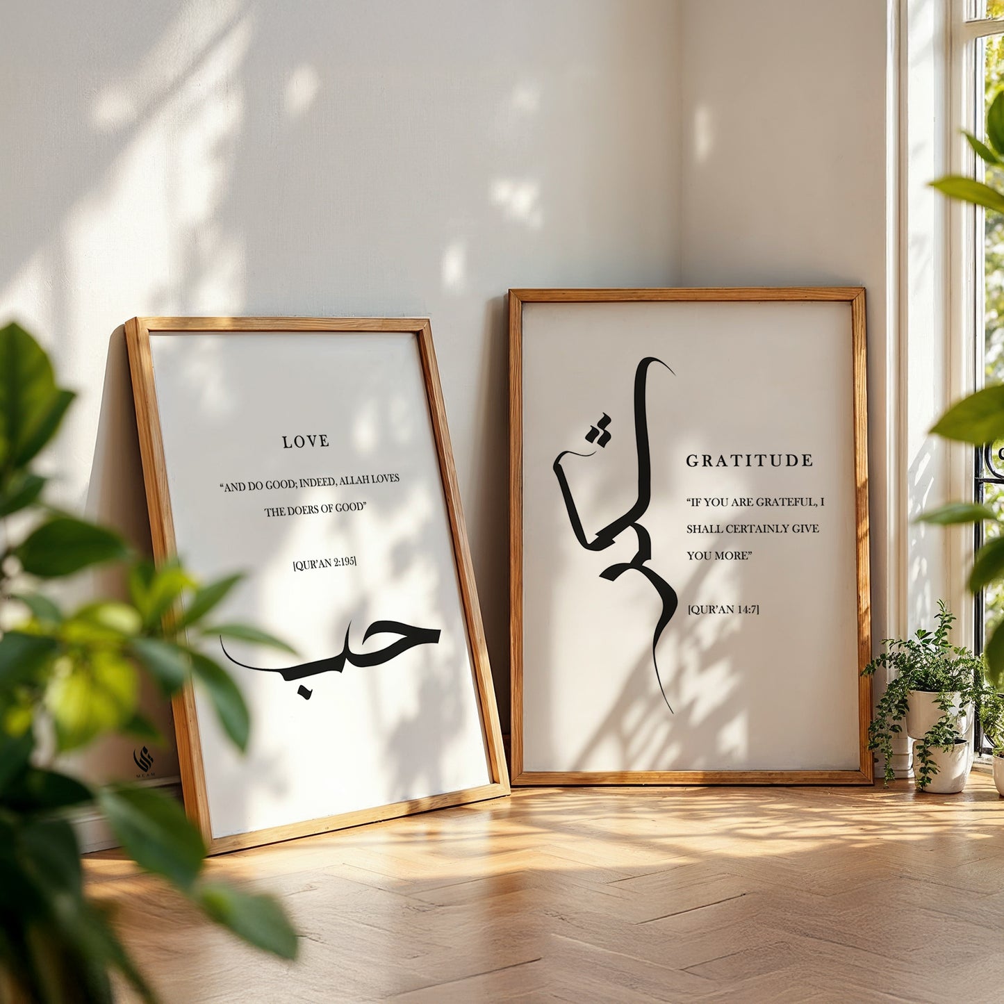 Two framed prints with Arabic calligraphy and text on a wooden floor with plants. Modern Islamic decor with Sabr Shukr Hubb wall art prints in black Arabic calligraphy on a white background, elegant Quran quote posters for a Muslim home interior.