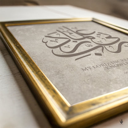 Framed artwork with Arabic calligraphy and English text on a wooden surface