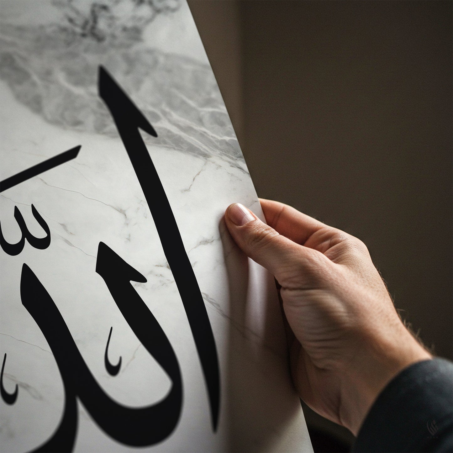 Hand holding a marble surface with Arabic calligraphy