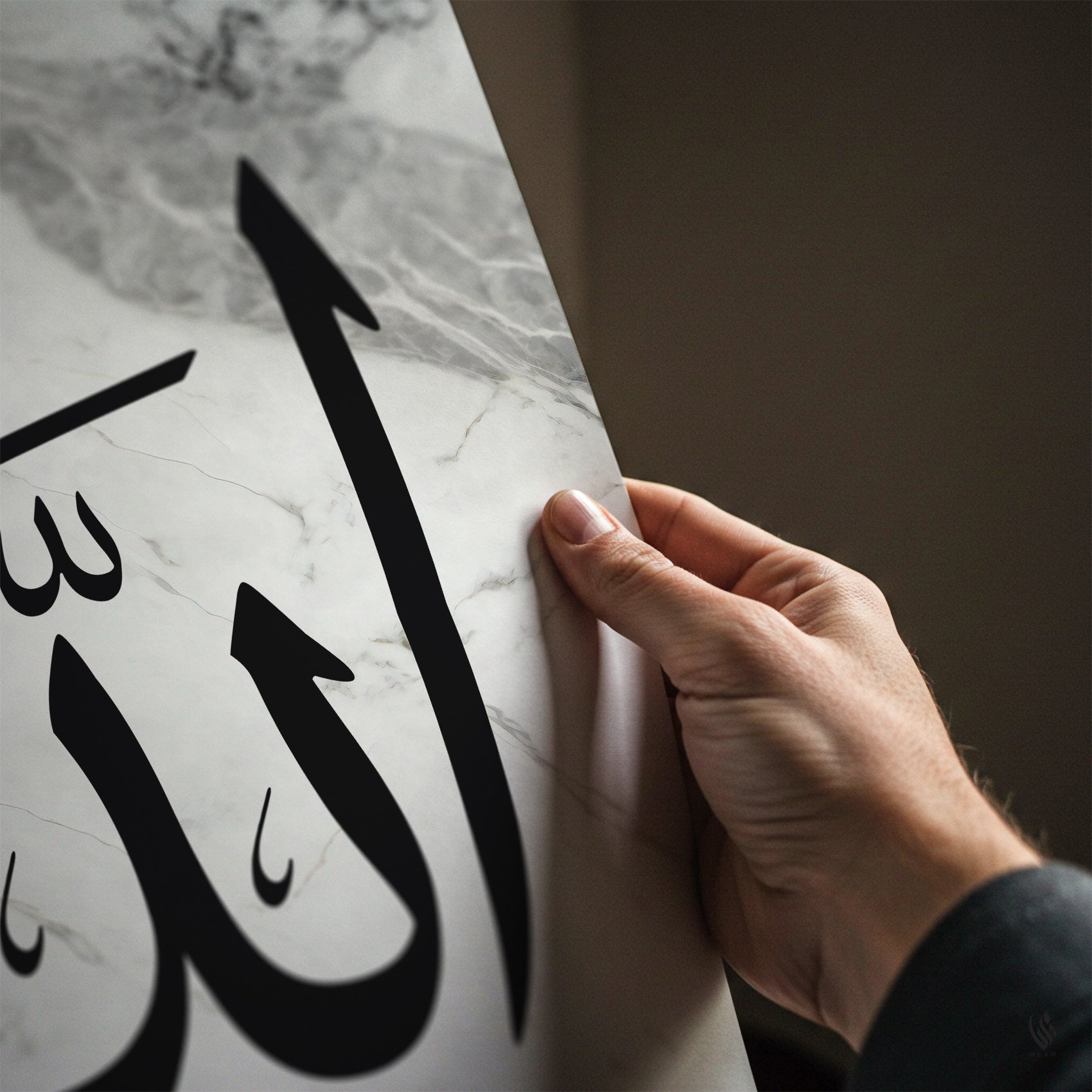 Hand holding a marble surface with Arabic calligraphy