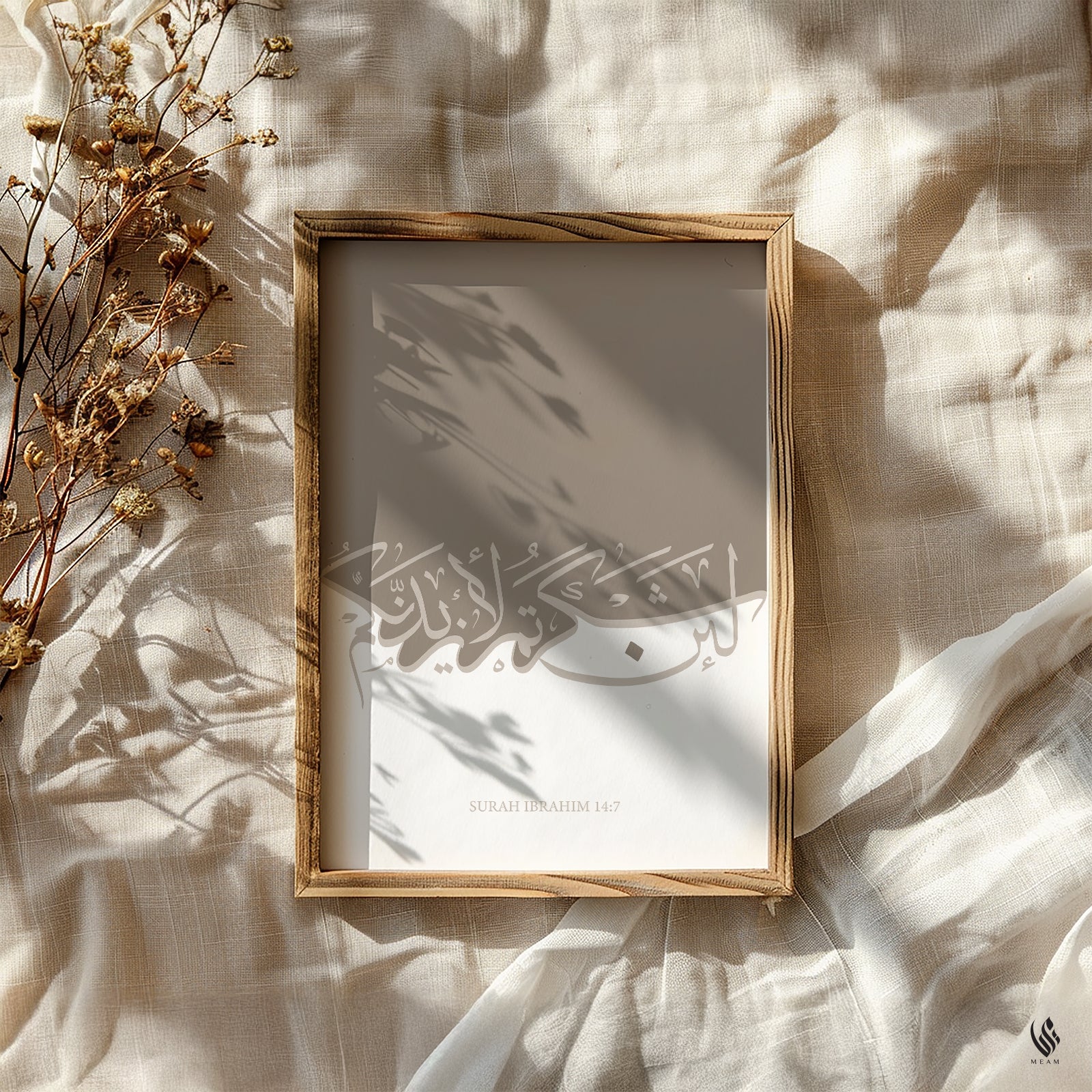 Framed artwork with Arabic calligraphy on a textured surface with dried flowers. Minimalist Quran wall art, Surah Ibrahim 14:7, beige and white palette, framed art print