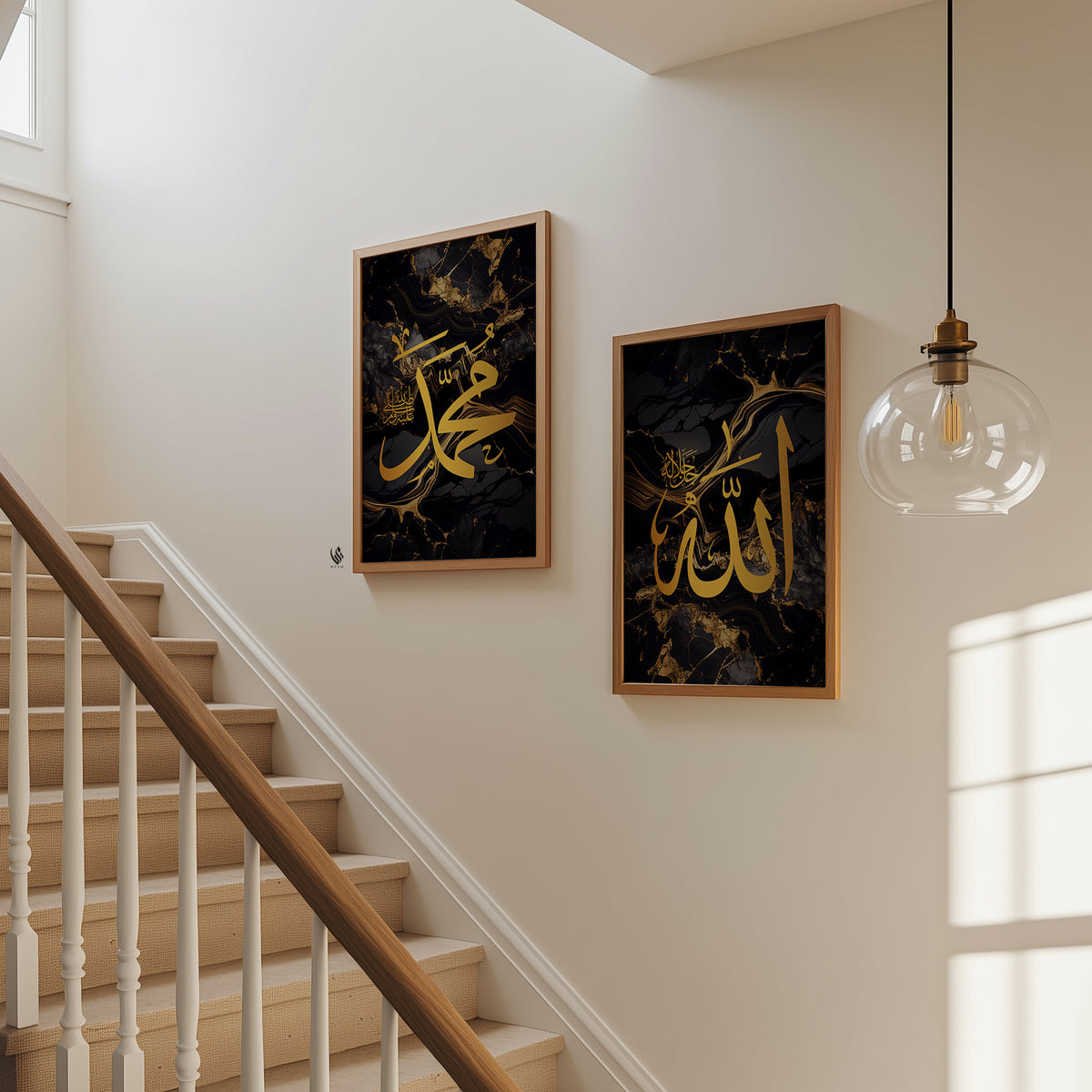 Two framed Islamic wall art prints with gold Arabic calligraphy on a black marble background, displayed on a beige wall next to a wooden staircase and a hanging glass globe light.