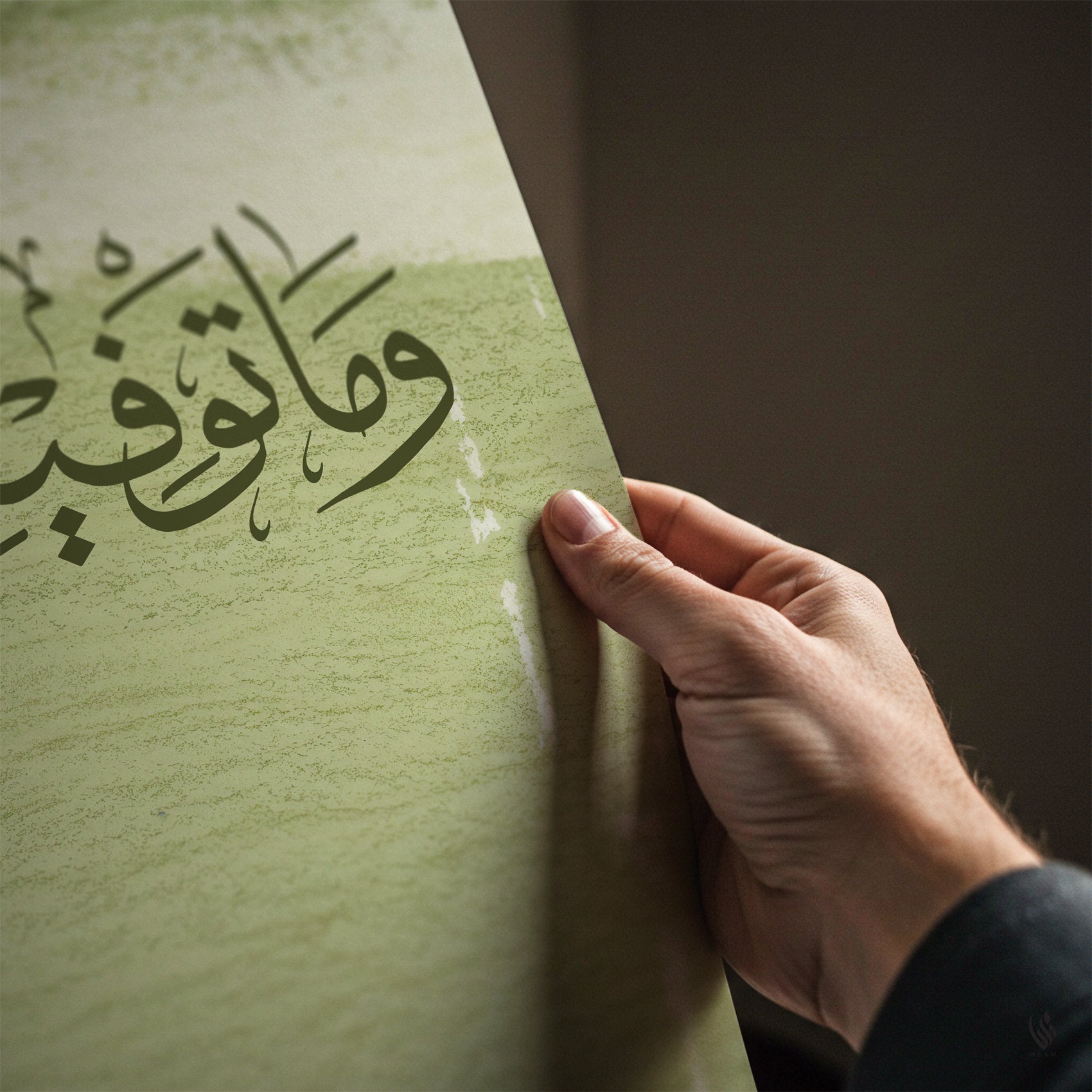 Hand touching a textured green surface with Arabic calligraphy