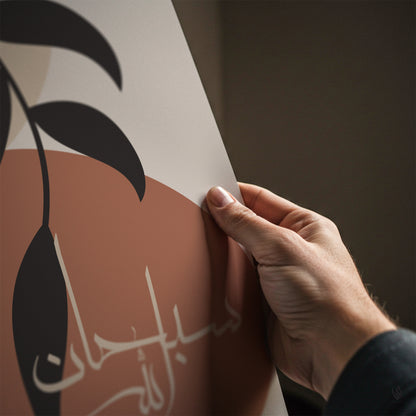 Hand applying a decorative sticker with Arabic text and leaf design on a brown surface.