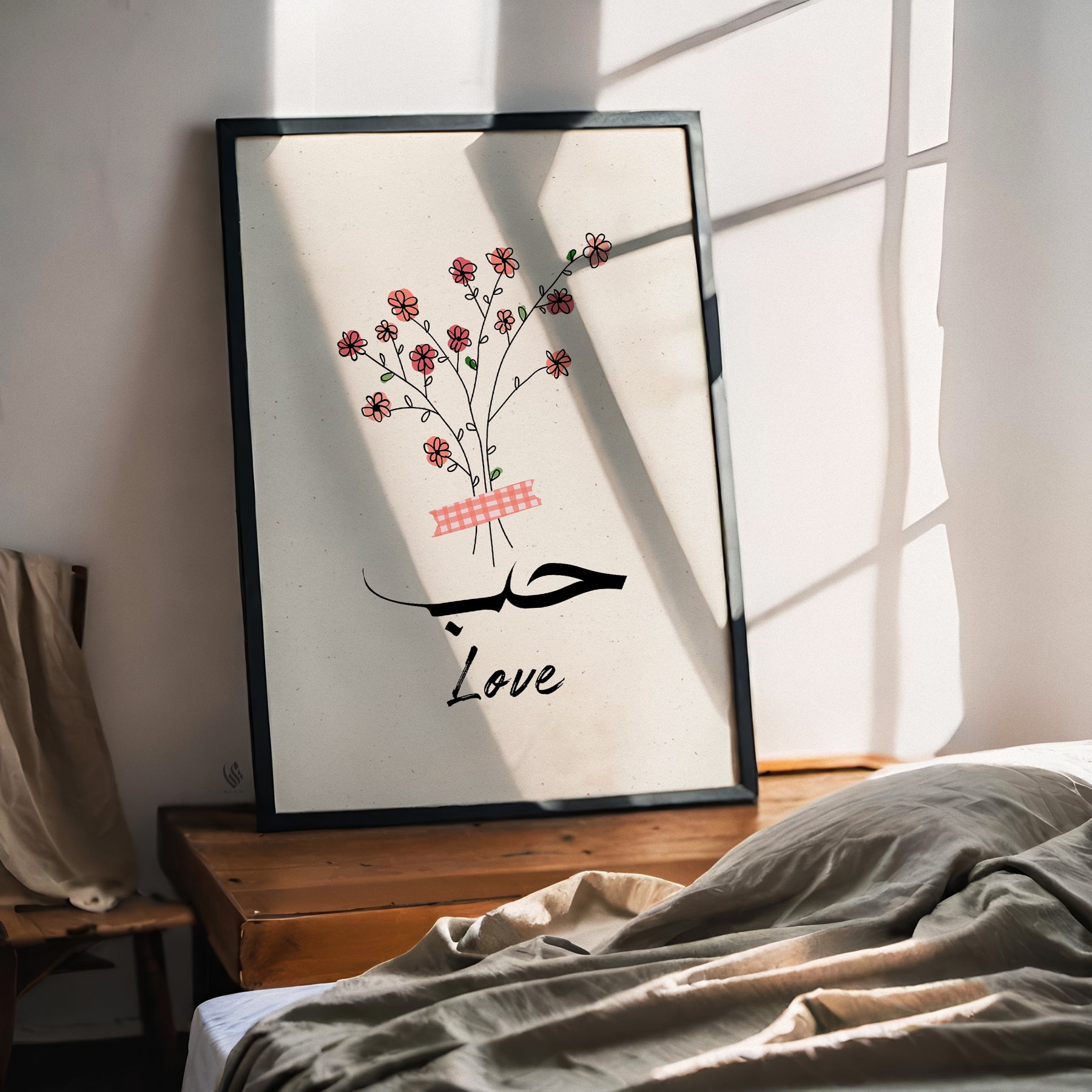 Framed artwork with floral design and Arabic text on a wall in a room.