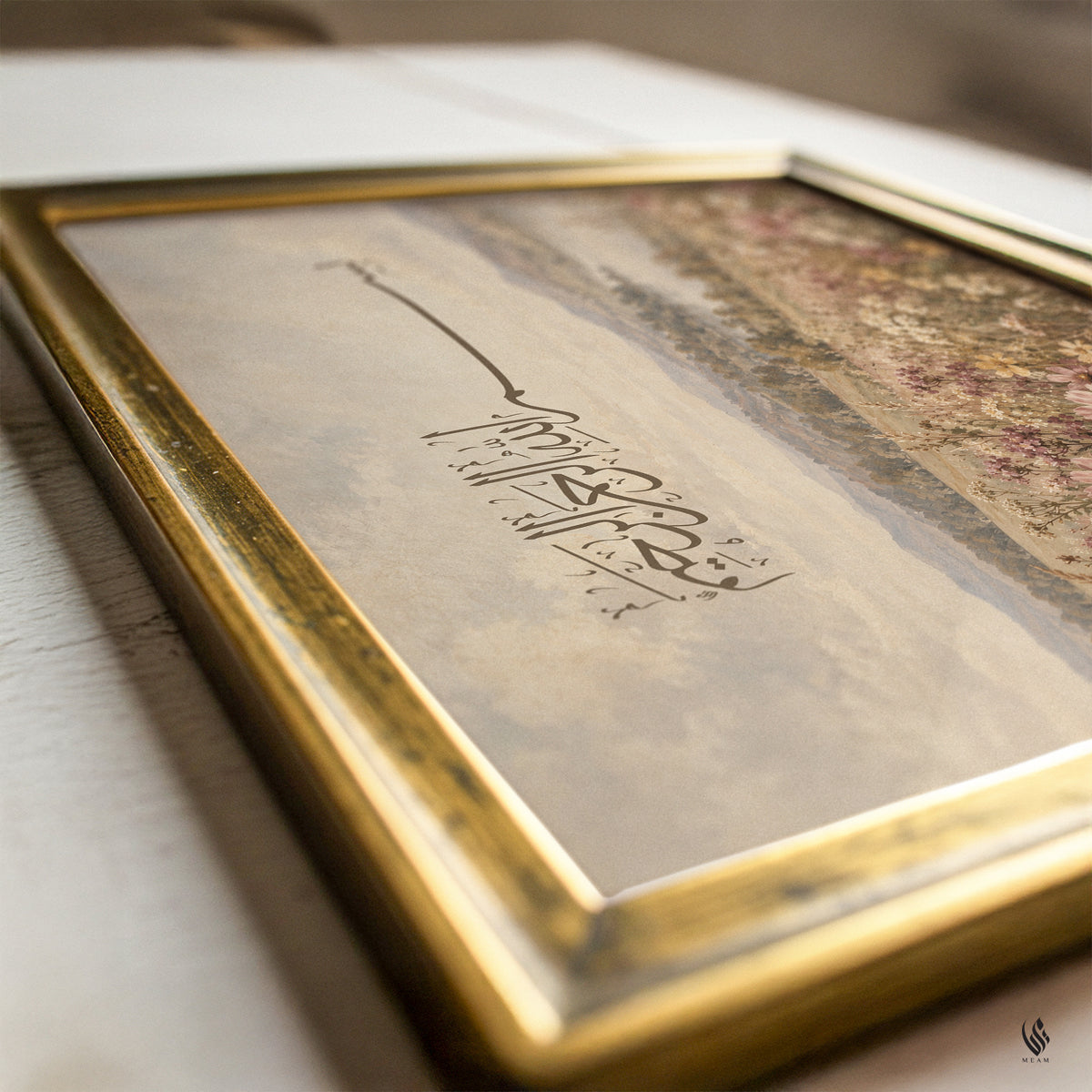 Close-up of Bismillah Islamic wall art displayed inside a traditional antique gold picture frame, photographed at an angle on a light surface.
Elegant dark brown Arabic calligraphy appears above a vintage countryside landscape with delicate wildflowers and soft rolling hills.
A warm neutral colour palette and fine painterly textures give the botanical landscape print a traditional, understated appearance.
